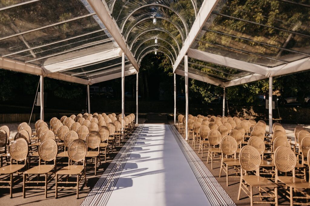 Beautiful outdoor wedding venue with stylish seating under a transparent canopy